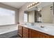 Bright bathroom features double sinks, vanity, large mirror and soaking tub under a window at 1279 N Blackstone Dr, Chandler, AZ 85224