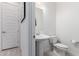Powder room with pedestal sink, white toilet and matching hardware, and tile flooring at 1330 E Monte Way, Phoenix, AZ 85042