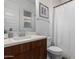 Bathroom with wood cabinet sink, white toilet, and shower behind a white curtain at 1330 E Monte Way, Phoenix, AZ 85042