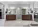 Dual sink bathroom with wood cabinets, modern mirrors and lighting, plus tile flooring at 1330 E Monte Way, Phoenix, AZ 85042