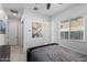 Simple bedroom with a dark upholstered bed, neutral walls, tile floors, and ceiling fan at 1330 E Monte Way, Phoenix, AZ 85042