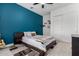 Stylish bedroom with a bold blue accent wall, a cozy queen-sized bed, and modern sliding door closet at 1330 E Monte Way, Phoenix, AZ 85042