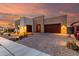 Modern home showcasing a stone facade, desert landscaping, and a stylish paver driveway at sunset at 1330 E Monte Way, Phoenix, AZ 85042