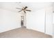 Bedroom featuring a ceiling fan, a large closet, and an open doorway at 15028 W Columbine Dr, Surprise, AZ 85379