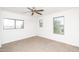 Bright bedroom featuring a ceiling fan and three sunlit windows at 15028 W Columbine Dr, Surprise, AZ 85379