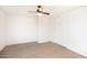 This carpeted bedroom features a ceiling fan and a spacious closet at 15028 W Columbine Dr, Surprise, AZ 85379