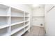 Well-lit laundry room with tile floors and a utility sink and white shelving at 15028 W Columbine Dr, Surprise, AZ 85379