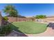 Beautiful backyard featuring a manicured lawn, waterfall, stone features and privacy wall at 15288 W Redfield Rd, Surprise, AZ 85379