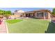 Large backyard with lush artificial turf, pool, and outdoor dining at 15288 W Redfield Rd, Surprise, AZ 85379