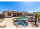 Entertainer's backyard featuring a custom pool, hot tub, and a putting green at 15288 W Redfield Rd, Surprise, AZ 85379