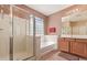 Well-lit bathroom featuring a shower and tub combination, a glass block window, and neutral finishes at 15288 W Redfield Rd, Surprise, AZ 85379