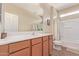 Bright bathroom featuring a large mirror, vanity, toilet and shower with tub at 15288 W Redfield Rd, Surprise, AZ 85379