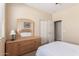 Bedroom with neutral walls, carpet, and closet space along with wooden dresser and decor at 15288 W Redfield Rd, Surprise, AZ 85379