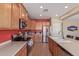 Bright kitchen with stainless steel appliances, wooden cabinets, an island with sink, and a view into the dining area at 15288 W Redfield Rd, Surprise, AZ 85379