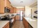 Well-lit kitchen with stainless steel appliances, including a range, microwave, and refrigerator, and a convenient sink setup at 15288 W Redfield Rd, Surprise, AZ 85379