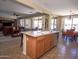 Open kitchen featuring an island with sink and seating, and a seamless transition to the adjacent living and dining areas at 15288 W Redfield Rd, Surprise, AZ 85379