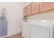 Laundry room featuring white washer and dryer and wall shelving with storage and ironing board at 15288 W Redfield Rd, Surprise, AZ 85379
