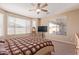 Bright main bedroom featuring multiple windows, neutral paint, soft carpet, and a ceiling fan at 15288 W Redfield Rd, Surprise, AZ 85379