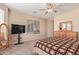 Cozy main bedroom showcasing a comfortable bed, soft carpet, natural light, and a large flat-screen TV at 15288 W Redfield Rd, Surprise, AZ 85379
