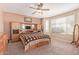 Spacious main bedroom featuring carpet floors, a ceiling fan, a large window, and an entertainment center at 15288 W Redfield Rd, Surprise, AZ 85379