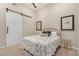 Bedroom featuring a white sliding barn door and neutral color scheme at 15550 S 5Th Ave # 130, Phoenix, AZ 85045