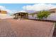 A spacious backyard featuring a stylish pergola, complemented by a brick-lined walkway and lush greenery at 16183 W Devonshire Ave, Goodyear, AZ 85395