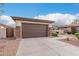 Attached two car garage with brown door, stone veneer accents, and concrete driveway at 16183 W Devonshire Ave, Goodyear, AZ 85395