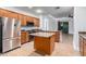Well-lit kitchen showcasing wooden cabinets, stainless steel appliances, and a functional island at 16183 W Devonshire Ave, Goodyear, AZ 85395