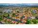 Stunning aerial view of a community with red tile roofs and lush landscaping near a lake at 1633 E Lakeside Dr # 98, Gilbert, AZ 85234