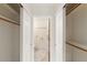 Walk-in closet with built-in shelving leading to bathroom with marble floors at 1633 E Lakeside Dr # 98, Gilbert, AZ 85234