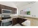 Kitchen with stainless steel appliances, dark cabinets, granite countertops and corner sink at 1633 E Lakeside Dr # 98, Gilbert, AZ 85234