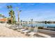 Poolside lounge chairs line the water with a beautiful lake and palm trees in the background at 1633 E Lakeside Dr # 98, Gilbert, AZ 85234