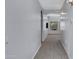 Neutral hallway leads to a living area, showcasing light gray walls, plush carpeting, and tasteful lighting at 1650 S Crismon Rd # 86, Mesa, AZ 85209