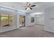 Spacious living room featuring large windows, access to a patio, neutral carpet, and modern light fixtures at 1650 S Crismon Rd # 86, Mesa, AZ 85209