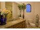 Bathroom vanity with granite countertop, a framed mirror, and decorative vase with flowers at 16716 S 32Nd Ln, Phoenix, AZ 85045