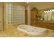Luxurious bathroom with tub, glass block wall, and custom cabinets at 16716 S 32Nd Ln, Phoenix, AZ 85045
