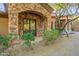 Stone archway at front entrance with an ornamental iron door and landscaped yard offer charming curb appeal at 16716 S 32Nd Ln, Phoenix, AZ 85045