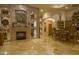Living room featuring a stone fireplace, travertine floors, and a bar with barstool seating at 16716 S 32Nd Ln, Phoenix, AZ 85045