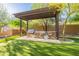 Backyard features a stylish outdoor kitchen with a built-in grill, stone accents, and lush green lawn at 16716 S 32Nd Ln, Phoenix, AZ 85045