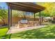 Outdoor kitchen featuring a built-in grill, stone counter, and lush green artificial grass at 16716 S 32Nd Ln, Phoenix, AZ 85045