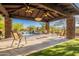 Inviting outdoor living space with stone columns, ceiling fans, and comfortable seating near the pool at 16716 S 32Nd Ln, Phoenix, AZ 85045