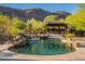 A backyard swimming pool with a rock waterfall and an outdoor kitchen at 16716 S 32Nd Ln, Phoenix, AZ 85045