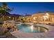 Backyard view of the pool and outdoor living space featuring lush desert landscaping at twilight at 16716 S 32Nd Ln, Phoenix, AZ 85045