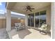 Inviting covered patio with seating, ceiling fan, and sliding glass doors at 1749 W Posada St, Coolidge, AZ 85128