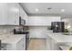 The bright kitchen features ample white cabinets, stainless steel appliances, and a functional island with bar seating at 1749 W Posada St, Coolidge, AZ 85128