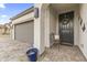 Cozy front porch with a wrought-iron bench, decorative wall art, and welcoming wreath on the dark-colored front door at 1749 W Posada St, Coolidge, AZ 85128