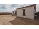 Partial side view of a home's unlandscaped backyard surrounded by dirt and a partial block wall at 18564 W Cathedral Rock Dr, Goodyear, AZ 85338