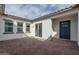 Private backyard featuring a brick-paved patio, windows, and a door leading inside at 18564 W Cathedral Rock Dr, Goodyear, AZ 85338