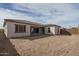 Wide angle shot of an unlandscaped backyard featuring dirt and partial view of the home's exterior at 18564 W Cathedral Rock Dr, Goodyear, AZ 85338