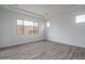 Unfurnished bedroom with wood-style tile flooring, white walls, and a window at 18564 W Cathedral Rock Dr, Goodyear, AZ 85338